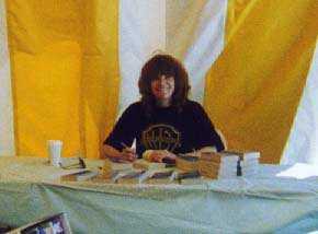 Signing books under a yellow tent